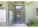 Elegant front entrance with a decorative glass door, stone walkway, and manicured landscaping at 2750 Coral Reef Way, Tavares, FL 32778