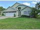 Charming single-story home featuring a lush front lawn, manicured landscaping, and an attached two-car garage at 2750 Coral Reef Way, Tavares, FL 32778