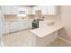 Bright kitchen with white cabinets, tile flooring, and modern stainless steel appliances at 2750 Coral Reef Way, Tavares, FL 32778