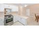 Well-lit kitchen with stainless steel appliances, white cabinets, and a convenient breakfast bar area at 2750 Coral Reef Way, Tavares, FL 32778