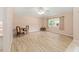Open-concept living room with wood flooring, neutral walls, and a large window offering a bright and airy feel at 2750 Coral Reef Way, Tavares, FL 32778