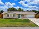 Lovely exterior view of a single story home featuring a well manicured lawn and cozy facade with inviting blue door at 2833 Beal St, Deltona, FL 32738