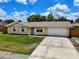 Beautiful single-story home with an attached garage, a well manicured lawn, and a private driveway at 2833 Beal St, Deltona, FL 32738