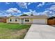 Inviting single-story home with a well-kept lawn, a driveway, and an attached two-car garage at 2833 Beal St, Deltona, FL 32738