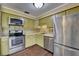 Updated kitchen featuring stainless steel appliances, decorative tile backsplash, and hardwood floors at 2833 Beal St, Deltona, FL 32738