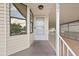 Inviting front porch with white railing and access to the carport and front door at 2921 Wekiva Rd, Tavares, FL 32778
