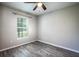 Bedroom featuring new gray floors, ceiling fan with light, and window with blinds at 30 Olive Cir, Ocala, FL 34472