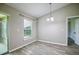 Dining room featuring new gray floors, window, modern light fixture, and access to the sunroom at 30 Olive Cir, Ocala, FL 34472