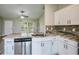 Bright kitchen with white cabinets, stone countertops, stainless steel appliances, and a sink with modern faucet at 30 Olive Cir, Ocala, FL 34472