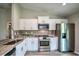 Well-lit kitchen featuring stainless steel appliances, white cabinets, and beautiful stone countertops at 30 Olive Cir, Ocala, FL 34472