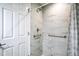 Shower with tiled wall, shower head, safety bars, and frosted shower door at 30 Olive Cir, Ocala, FL 34472