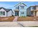 Charming two-story home with light blue siding, a green front door, and a nicely designed front yard at 3034 Voyager Ave, St Cloud, FL 34771