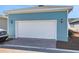 Detached two car garage with white door and light fixtures at 3034 Voyager Ave, St Cloud, FL 34771