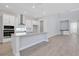 Open-concept kitchen with white cabinets, stainless steel appliances, and modern finishes at 3034 Voyager Ave, St Cloud, FL 34771