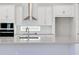 Stylish kitchen showcasing white cabinets, stainless steel range hood, and sleek countertops at 3034 Voyager Ave, St Cloud, FL 34771