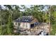 An aerial view of block home construction surrounded by mature trees in a partially cleared lot at 30551 Saffron Ave, Eustis, FL 32736