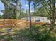 Image shows a home under construction on a wooded lot behind a pile of lumber at 30551 Saffron Ave, Eustis, FL 32736