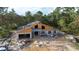 New home construction featuring block walls, wood framing, and an attached garage in a wooded community at 30551 Saffron Ave, Eustis, FL 32736