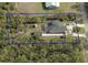 Aerial view of a large lot with a house, pool, and wooded surroundings in a private backyard at 31857 Dahlia Ct, Eustis, FL 32736
