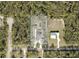An aerial view shows this home sits on a spacious 1.05 acre lot surrounded by dense trees at 31857 Dahlia Ct, Eustis, FL 32736