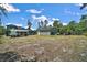 Expansive backyard with detached garage, screened-in patio and garden beds creates an outdoor space for leisure and gardening at 31857 Dahlia Ct, Eustis, FL 32736