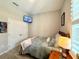 Cozy bedroom features plush bedding, mounted TV, and a spacious closet for ample storage at 31857 Dahlia Ct, Eustis, FL 32736