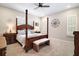 Cozy bedroom featuring a four-poster bed, shutters, and elegant decor at 31857 Dahlia Ct, Eustis, FL 32736