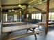 Spacious community center interior featuring multiple picnic tables, fans, and large windows at 31857 Dahlia Ct, Eustis, FL 32736