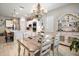Open concept kitchen and dining area with a chandelier, white cabinets, and hardwood floors at 31857 Dahlia Ct, Eustis, FL 32736