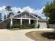 A beautiful single-story home with a gray exterior, white trim, and a driveway leading to an attached garage at 31857 Dahlia Ct, Eustis, FL 32736