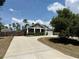A charming single-story home featuring a gray exterior and a long driveway with mature landscaping at 31857 Dahlia Ct, Eustis, FL 32736