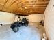 The garage showcases a black golf cart parked on the concrete floor beneath an exposed wood beam ceiling at 31857 Dahlia Ct, Eustis, FL 32736
