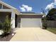 Garage exterior with white door and space for two cars, plus a lovely front yard at 31857 Dahlia Ct, Eustis, FL 32736