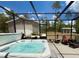 Beautiful screened-in hot tub with backyard views and outdoor seating area at 31857 Dahlia Ct, Eustis, FL 32736