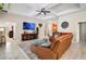 Comfortable living room with a ceiling fan, tile flooring, and a TV above the console table at 31857 Dahlia Ct, Eustis, FL 32736