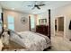 Spacious bedroom with a four-poster bed, ceiling fan, and an ensuite bathroom entrance at 31857 Dahlia Ct, Eustis, FL 32736