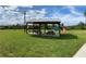 An outdoor picnic area with picnic tables and a playground beyond on the community grounds at 31857 Dahlia Ct, Eustis, FL 32736