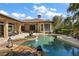 Backyard view of a pristine pool and spa, set against a backdrop of lush landscaping at 32543 Hawks Lake Ln, Sorrento, FL 32776