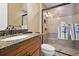 Bathroom featuring granite countertops, wood cabinetry, and tiled shower for an inviting experience at 32543 Hawks Lake Ln, Sorrento, FL 32776