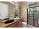 Bathroom with double vanity, a granite countertop, modern fixtures, and a sleek glass-enclosed shower at 32543 Hawks Lake Ln, Sorrento, FL 32776