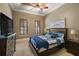 Cozy bedroom with stylish wood bed, ceiling fan, and natural light for a restful night's sleep at 32543 Hawks Lake Ln, Sorrento, FL 32776