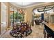 Sunlit dining area with a round table, chandelier, and views of the pool at 32543 Hawks Lake Ln, Sorrento, FL 32776