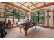 Spacious game room with a pool table, large windows offering natural light and scenic views, and an adjacent seating area at 32543 Hawks Lake Ln, Sorrento, FL 32776