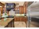 Chef's kitchen with wood cabinetry, granite countertops, and stainless steel refrigerator at 32543 Hawks Lake Ln, Sorrento, FL 32776