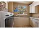 Bright laundry room with granite countertops, storage cabinets, and modern washing machine ready for everyday tasks at 32543 Hawks Lake Ln, Sorrento, FL 32776