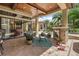 Covered patio with fireplace, ceiling fan, outdoor seating, and views of the sparkling pool and lush backyard at 32543 Hawks Lake Ln, Sorrento, FL 32776