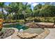 Backyard oasis showcases a private pool with a waterfall feature, lush landscaping, and serene setting at 32543 Hawks Lake Ln, Sorrento, FL 32776