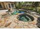 A luxurious pool and spa area featuring stone accents and inviting water features for ultimate relaxation at 32543 Hawks Lake Ln, Sorrento, FL 32776