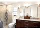 Bathroom featuring stone tiled shower, a double vanity, granite countertop, and modern light fixtures at 3430 Laurel Dr, Mount Dora, FL 32757