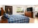 Bedroom features a large bed, dresser, and television with a view to the outside from the window at 3430 Laurel Dr, Mount Dora, FL 32757